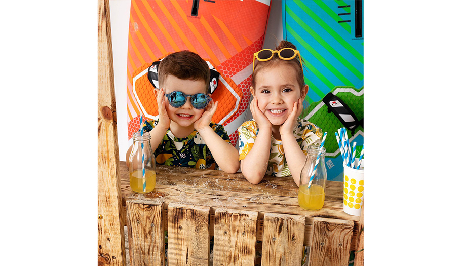 Uśmiechnięte dzieci na plaży - sesja zdjęciowa ubrań marki Go Charlie - wzory Weroniki Wolskiej