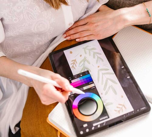 Dziewczyna, graficzka wybierająca kolory do projektu na tablecie graficznym.