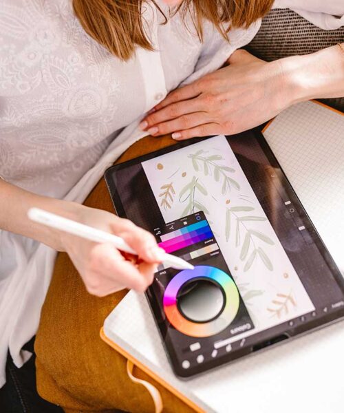 Dziewczyna, graficzka wybierająca kolory do projektu na tablecie graficznym.