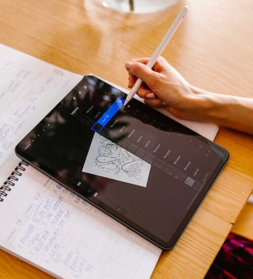 Kobieta podczas tworzenia grafik, ilustracji w programie graficznym na tablecie.