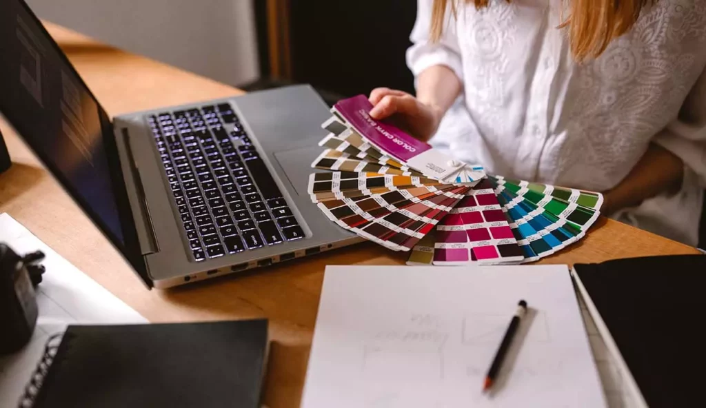 Jak wygląda praca jako grafik komputerowy? Dziewczyna, graficzka wybiera kolory.