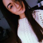 Natalia Rogala — opinia o Kursie Projektowania Graficznego Akademii Projektowania; młoda kobieta z długimi, ciemnymi włosami i białym swetrem, uśmiechnięta, w domowym wnętrzu.