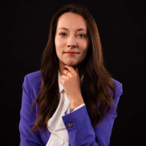 Dorota Kozioł – absolwentka Kursu Projektowania Graficznego w Akademii Projektowania prowadzonej przez Weronikę Wolską – pozuje do zdjęcia w ramach artykułu blogowego w formie wywiadu. Zdjęcie przedstawia młodą graficzkę ubraną w żółtą marynarkę, trzymającą tablet i ołówek, co symbolizuje jej pracę w branży kreatywnej. Dorota opowiada o zdobywaniu doświadczenia w projektowaniu graficznym, grafice komputerowej i designie oraz o tym, jak kurs umożliwił jej rozpoczęcie kariery jako freelancer i rozwój w zawodzie grafika.